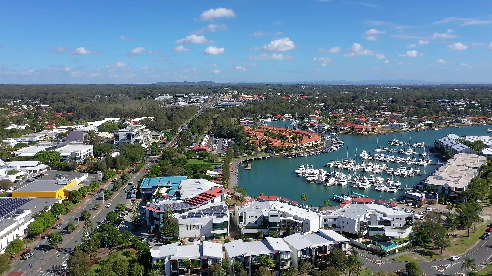 Drone view of LJ Hooker Property Centre on Shore Street West, with the Raby Bay marina behind